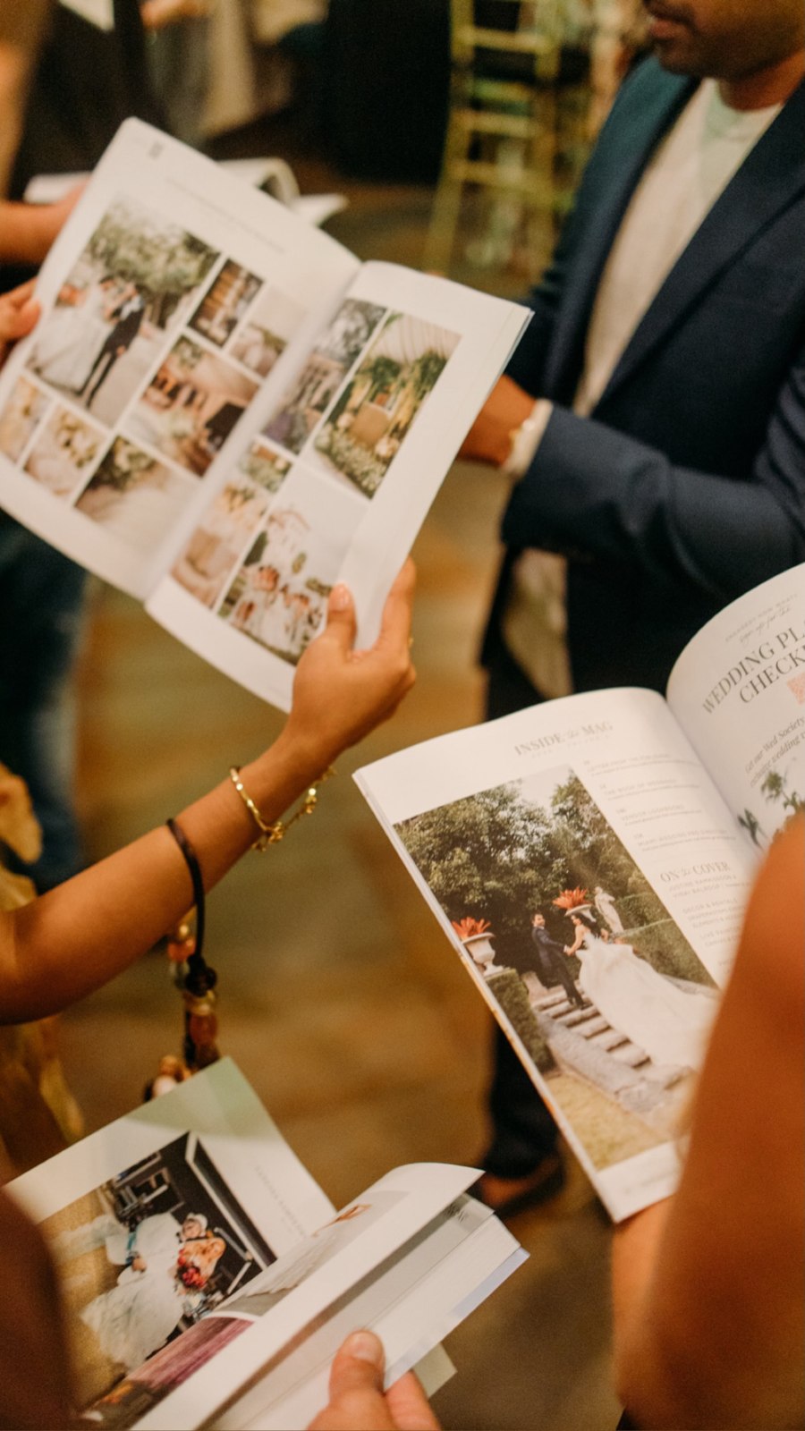 Guests browsing event magazines at a brand gathering