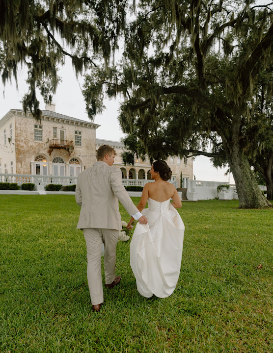 The couple walking beneath oak trees at their wedding