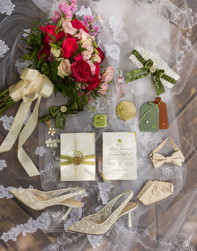 The couple’s wedding invitations, bridal shoes and colorful bouquet