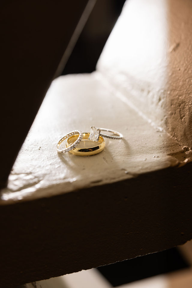 Gold wedding bands resting in warm window light