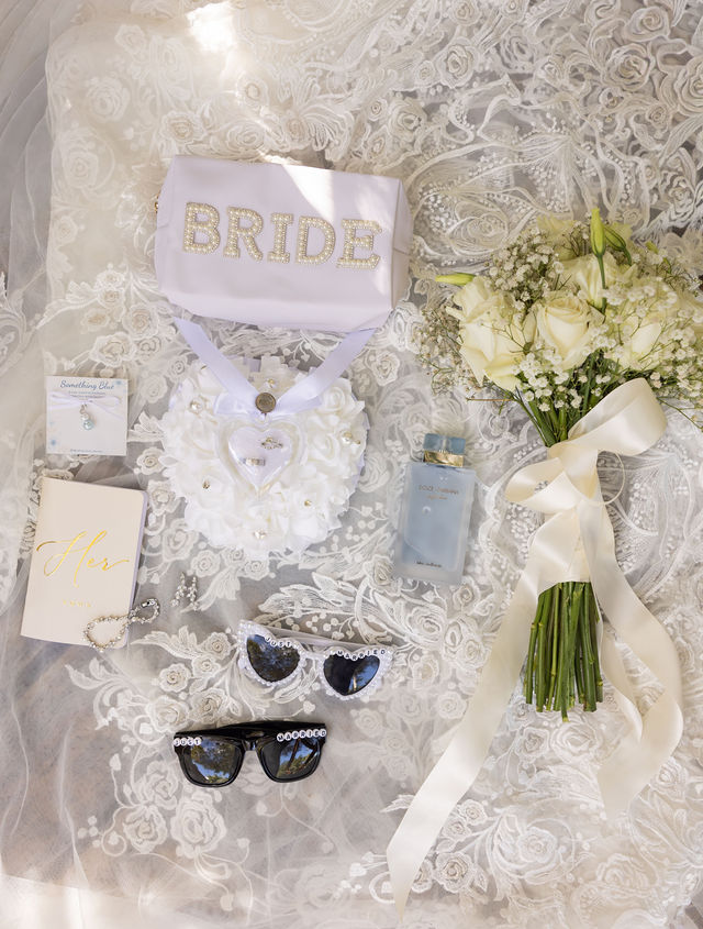 The couple’s white bridal accessories and bouquet on delicate lace