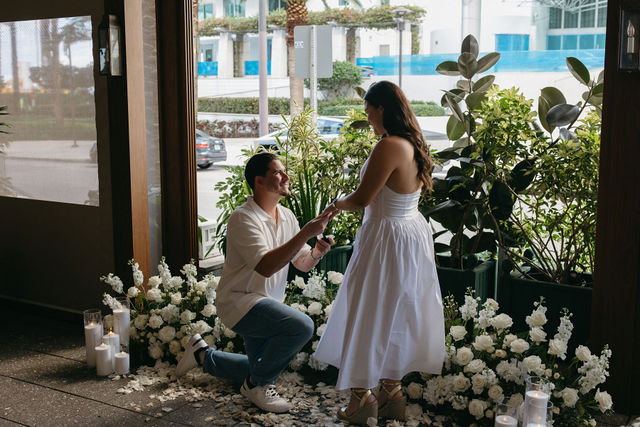 The proposal surrounded by white florals and rose petals