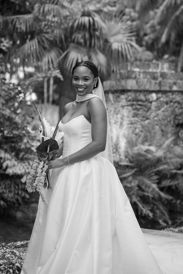 A bride holding her bouquet in a tropical garden