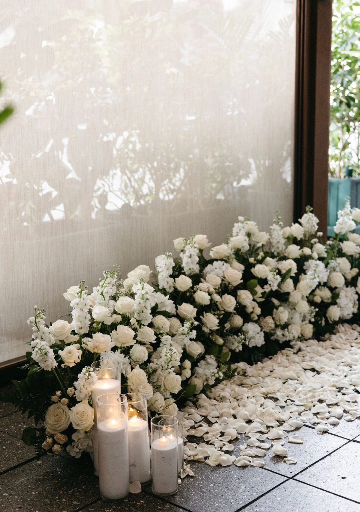 White flowers and candles against softly lit windows