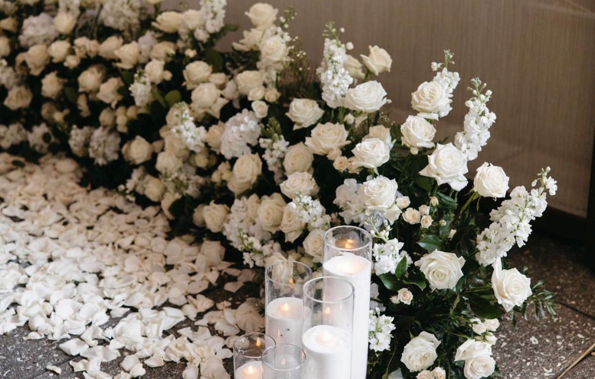A close-up of white blooms and glass candle holders