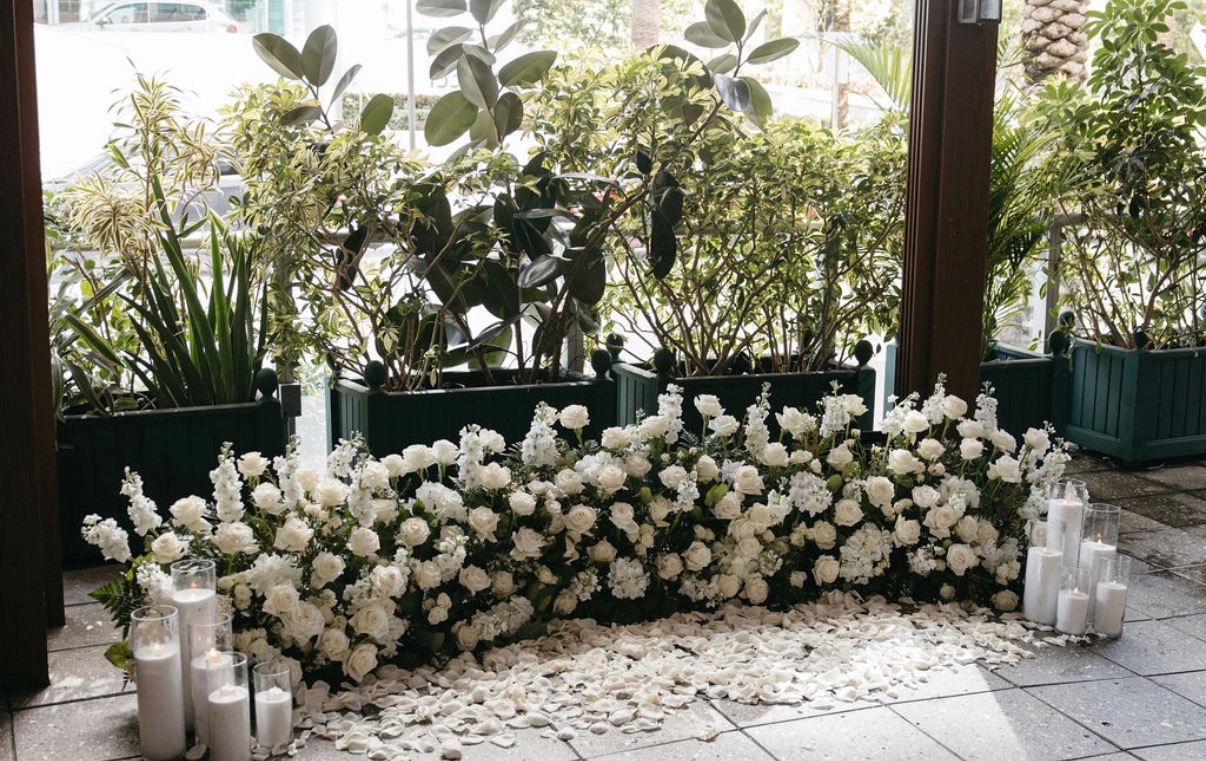 White floral proposal setting framed by greenery