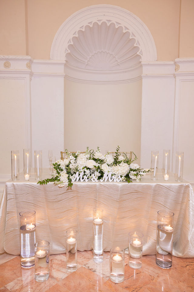 A candlelit sweetheart table with white florals and soft blush linens