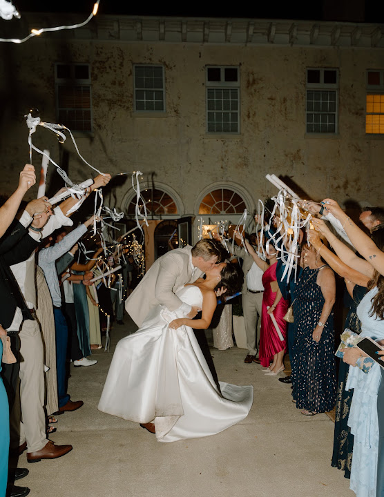 The Dyer couple celebrating beneath ribbons held by their guests